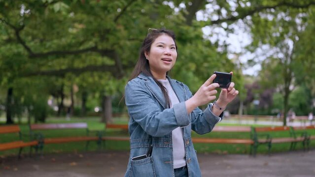 wonderful moment asia woman traveller impressive sight seeing she use smartphone taking photo and video in the central public park in Vienna Hungary,asian woman travel alone concept