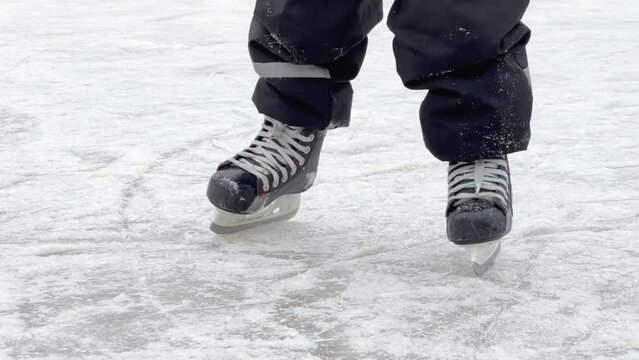 close up of child feet learning to skate on ice skating rink