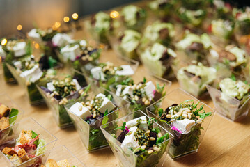 Beet salad with feta cheese cream with pesto sauce and pine nuts. Salads in disposable plastic...