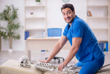 Young male doctor and skeleton patient at the hospital