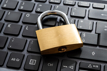 Closed padlock, placed above a pc keyboard. Protection of personal and sensitive data. Privacy.