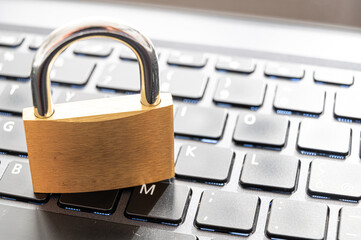 Closed padlock, placed above a pc keyboard. Protection of personal and sensitive data. Privacy.