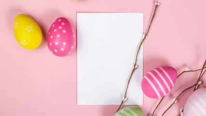 Mockup white greeting card, easter eggs and envelope on a pink background. Copy space