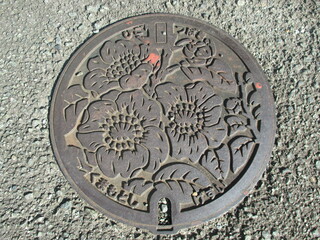 Obraz na płótnie Canvas 熊本市の花「肥後椿」をデザインした下水管マンホール蓋