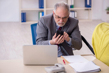 Old male employee looking after new born at workplace