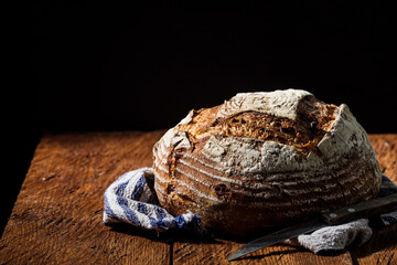 Rustic crispy sourdough bread with cranberries on a wooden table