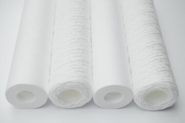 Cartridges for water treatment systems on white background.