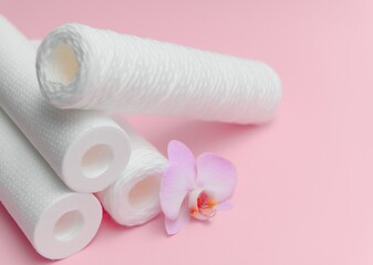 filter cartridges for water on a pink background. Installation of reverse osmosis water purification system.
