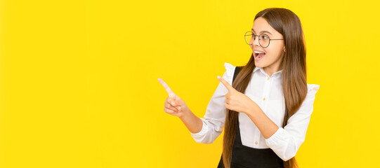 happy teen girl in glasses for vision protection pointing finger on copy space. Child face, horizontal poster, teenager girl isolated portrait, banner with copy space.