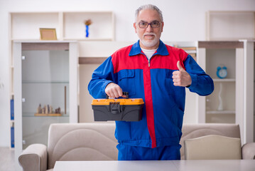 Old male carpenter holding toolbox
