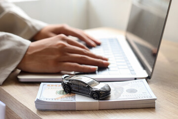 Close up of woman hands typing on laptop applying car loan, finance for car concept. 