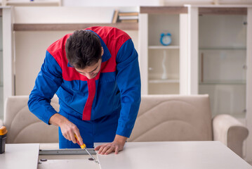 Young male carpenter working at home