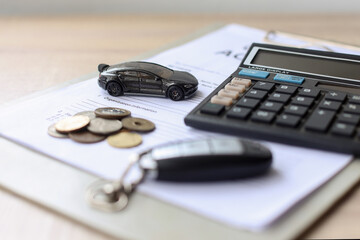 Black car and  key on loan document paper with coins and calculator, saving money and finance for...