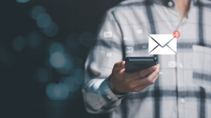 man reading electronic mail from smartphone,Email marketing and newsletter concept,Digital communication with email messages,Sending and receiving messages online with the email icon