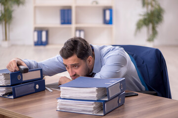 Young male employee and too much work in the office