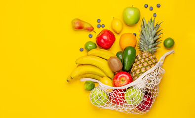 Shopping mesh bag full of healthy food on yellow