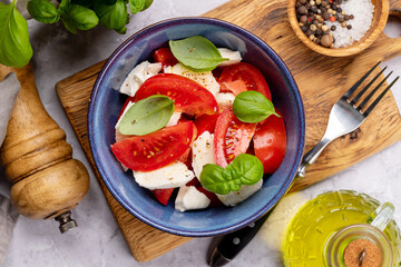 Caprese salad with ripe tomatoes, mozzarella cheese and garden basil