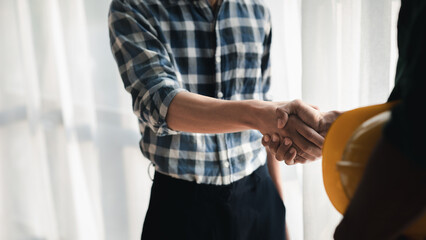 Team engineers and architects shake hands with the condo project owners after the meeting to present room plans and details of the condo building structure. Concept of building design and construction