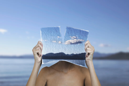 surreal woman with a painted sheet in front of her face equal to the landscape, surreal concept