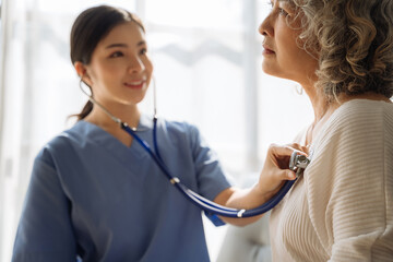 Doctor with stethoscope examining elderly patient, healthcare and medical concept.