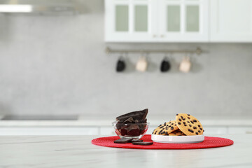 Delicious chocolate and tasty cookies on white marble table in kitchen. Space for text