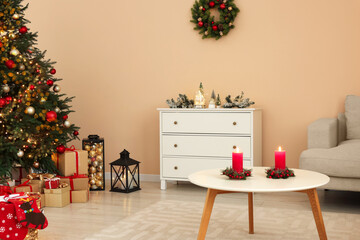 Christmas interior. Beautiful tree decorated with baubles in room with cozy furniture