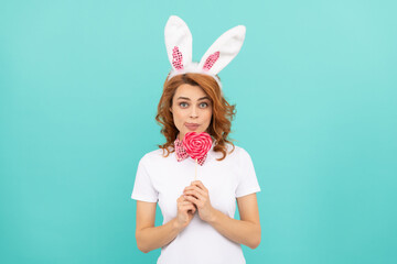 Obraz na płótnie Canvas funny easter woman wear bunny ears hold heart lollipop