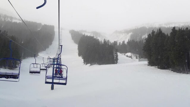 chairlift with skiers and  snowboarders at a ski resort in Alberta, Canada