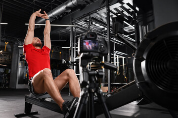 Plakat Man recording workout on camera at gym. Online fitness trainer