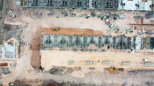 Aerial hyperlapse heavy machinery working directly above a construction site