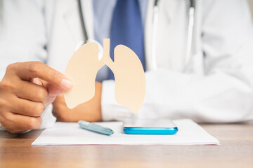 Doctor holding a lung shape symbol while sitting in the hospital
