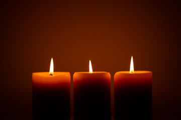 three burning candles in the dark. Memories and blessings
