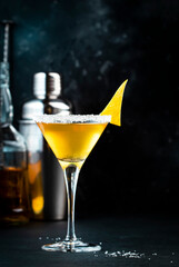 Sidecar alcoholic cocktail with cognac, liqueur, lemon juice and ice. Black background, bar tools, night atmosphere