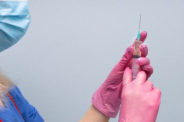 doctor holding a syringe with medicine in his hand.