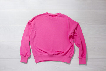 Pink sweatshirt mockup. Valentines Day concept shirt on wooden background. Copy space, template...