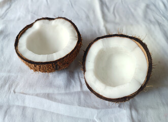 Coconut broken into two halves on white background. Isolated