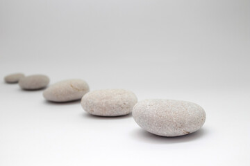 Row of smooth pebbles on white background