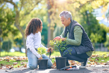Woman, child and plant while gardening in a park with trees in nature, agriculture or garden. Volunteer team planting for growth, ecology and sustainability for community environment on Earth day