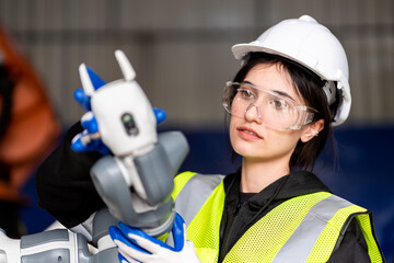 A team of male and female engineers meeting to inspect computer-controlled steel welding robots....
