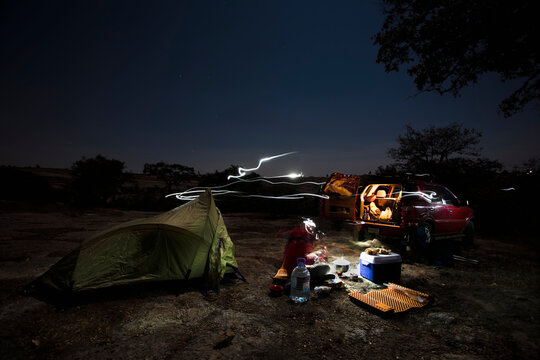 Armando Dattoli cooks dinner in his campsite at night in Caon de Aculco, Queretaro, Mexico.