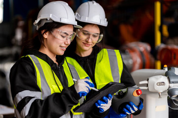 Fototapeta premium A team of male and female engineers meeting to inspect computer-controlled steel welding robots. Plan for rehearsals and installation for use.