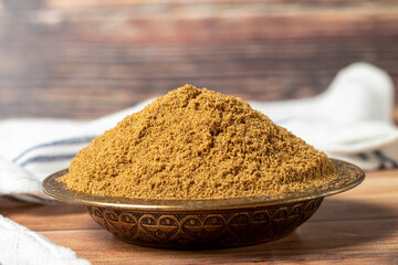 Powdered cumin spice. Cumin spice in bowl on wooden background. Dry spice concept. close up