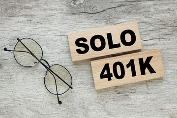 Solo 401k concept. on wooden blocks near glasses