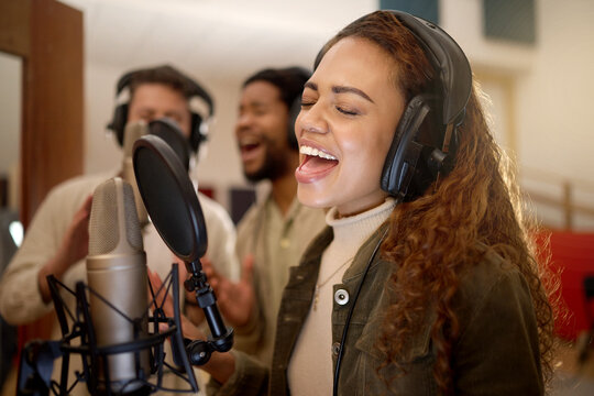 Woman, face or singing on studio microphone with backup singers in album, song or radio recording. Artist, musician or friends and production headphones in sound, voice or media performance for label