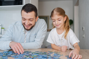 father and daughter playing with puzzles at home. Focus on man.