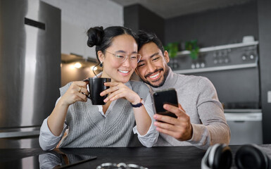 Love, coffee and couple with phone in home kitchen watching video online. Social media, tea and diversity of man and woman with mobile smartphone streaming movie or film and bonding at night in house