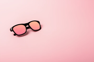 Black sunglasses with Multicolor Mirror Lens on pink background. Polarized sunglasses with UV...