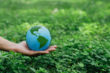 Business hands holding Earth with nature background.World environment day. Global community...