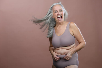 Portrait of senior woman in lingerie, studio shoot.