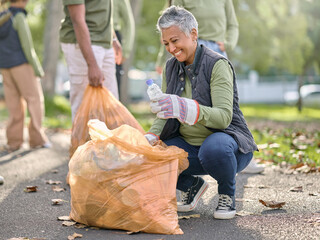 Trash, volunteer and elderly woman cleaning garbage, pollution or waste product for environment...